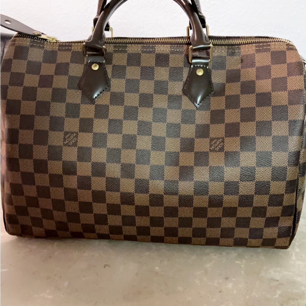 In great condition !
This is an authentic LOUIS VUITTON Damier Ebene Speedy 35.